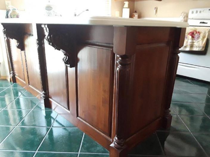 Maple Kitchen Cabinets with a custom stain and semi gloss lacquer. Arch raised panel cabinet doors and square raised panel doors and drawers. Corian countertops. Corbels and Island legs.