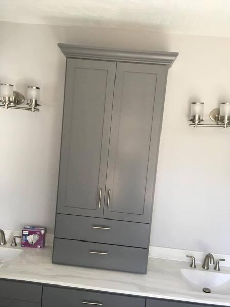 Grey painted medicine/linen bath cabinet with appliance pull.